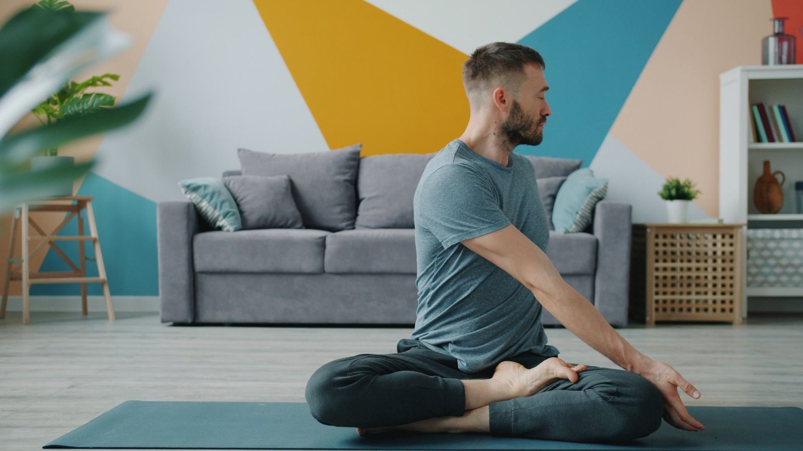 Homem praticando yoga em casa sentado em posição meditativa sobre tapete na sala de estar