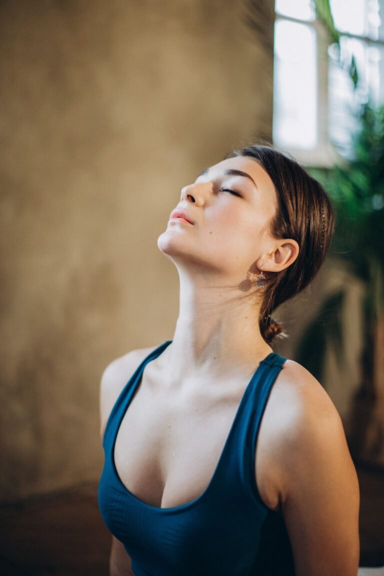 Mulher com olhos fechados e cabeça inclinada para trás em postura de respiração profunda e pranayama ilustrando ativação do nervo vago e regulação do sistema nervoso parassimpático