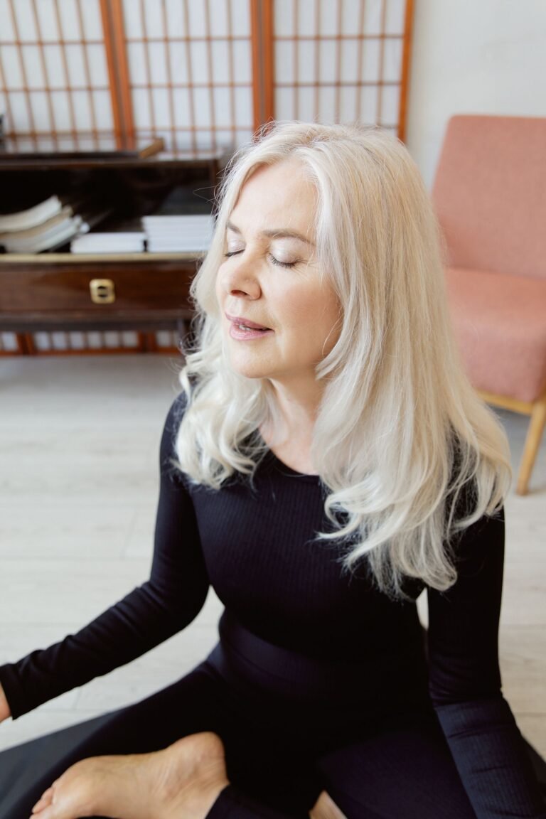 Mulher praticando respiração consciente sentada em postura de meditação